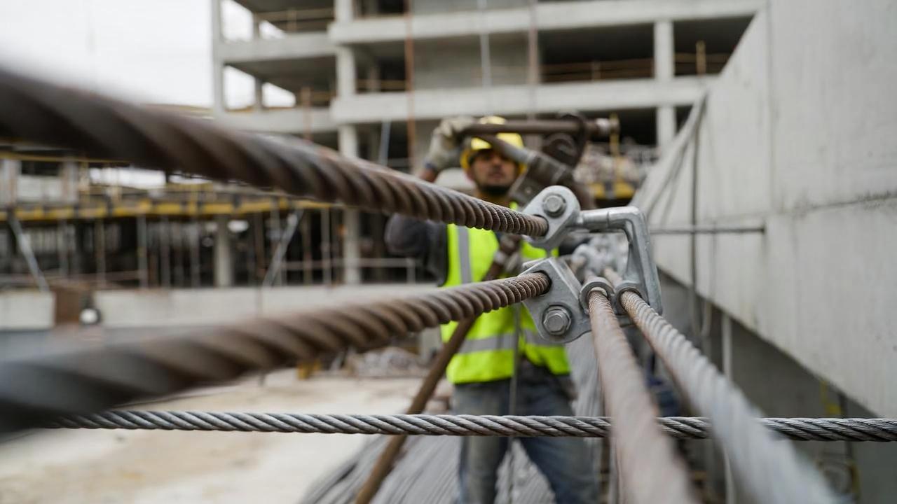 Crew detensioning a high-strength steel tendon at the anchor